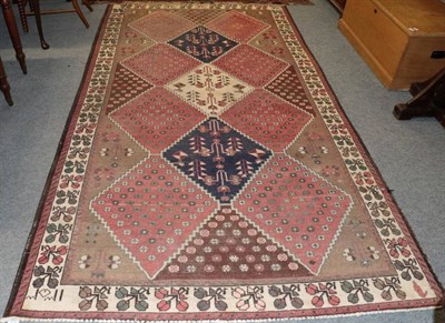 Lot 1271 - A West Persian village rug, the stepped diamond lattice field enclosed by floral borders, 298cm...