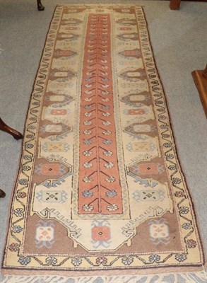 Lot 1274 - A narrow Melas runner, the field with flowering plant enclosed by ivory borders, 287cm by 90cm