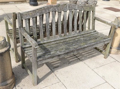 Lot 1300 - ^ A pair of wooden garden benches, with slatted seats, in weathered condition, 146cm wide