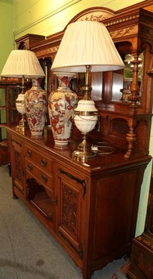 Lot 1313 - ^ A carved oak mirror backed sideboard circa 1900, with stylised brass hinges and carved...