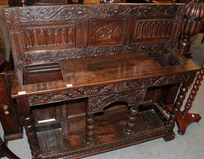 Lot 1414 - ^ A carved oak stick stand bearing date 1634, the base with two drip trays and bobbin turned...