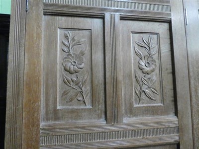 Lot 1434 - An Arts & Crafts Limed Oak Wardrobe, designed by Frederick Muntzer, three-door two-sectional...