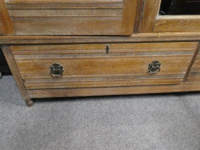 Lot 1434 - An Arts & Crafts Limed Oak Wardrobe, designed by Frederick Muntzer, three-door two-sectional...