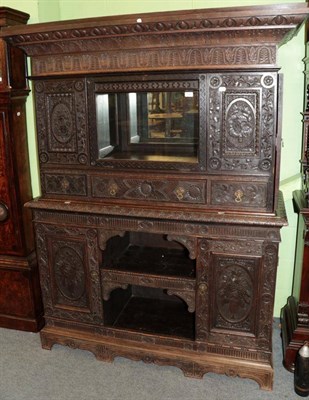 Lot 1440 - ^ A carved oak cupboard, the upper section as a drinks or display cabinet, with one real and...