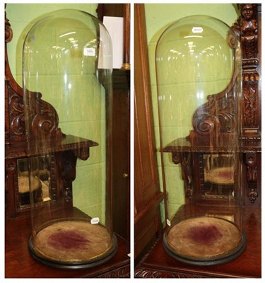 Lot 1455 - ^ A pair of late Victorian glass domes with circular ebonised bases, approximately 82cm high...