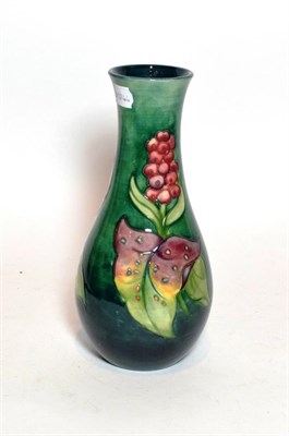 Lot 57 - A Walter Moorcroft Arum Lily pattern vase, on a green ground, impressed factory mark and blue...