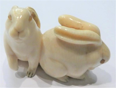 Lot 81 - A Japanese ivory netsuke, Meiji period (1868-1912) in the form of two hares, with amber eyes, 4.5cm