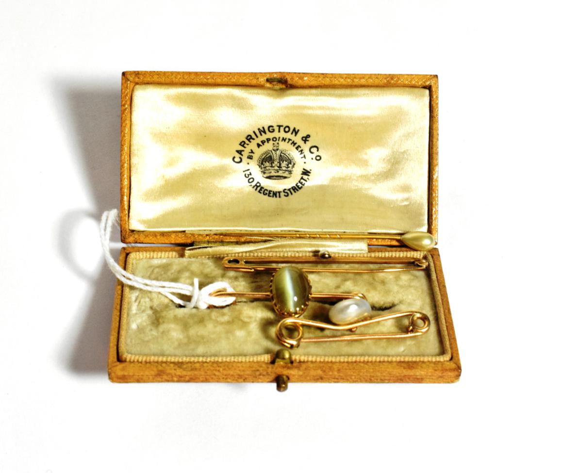Lot 96 - A cat's-eye chrysoberyl bar brooch, stamped '15', length 3.8cm; two pearl set bar brooches, one...