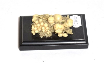 Lot 220 - A 19th century Dieppe ivory carving of various fruit, with leaves raised on black slate plinth...
