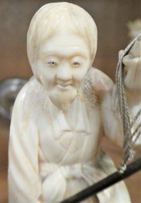 Lot 222 - A Japanese ivory okimono, Meiji period (1868-1912) in the form of a fisherman holding a wooden...