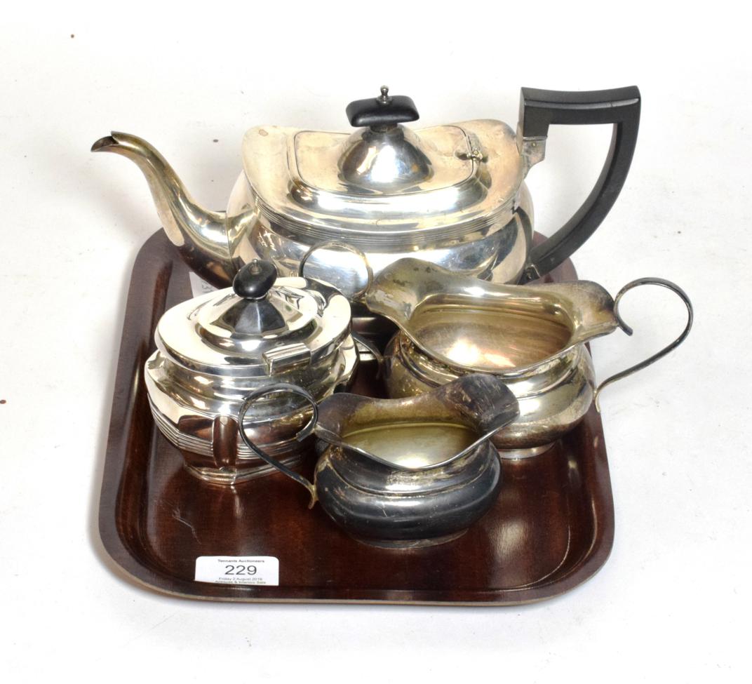 Lot 229 - A three-piece Edward VIII silver tea-service, each piece bombe, the teapot with composition...