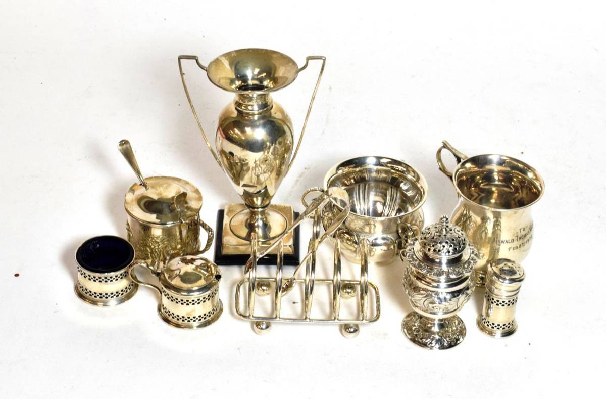 Lot 231 - A group of silver, including: a George IV pepperette, London, 1825; a silver vase, on wood...
