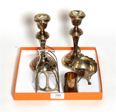Lot 250 - A group of silver, comprising: a pair of candlesticks, filled, by Broadway and Co., Birmingham,...