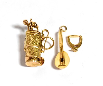 Lot 298 - Three charms comprising of a 9 carat gold bag of golf clubs; a stringed instrument, stamped...