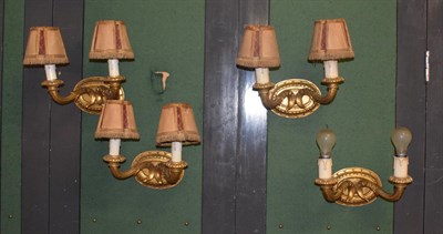 Lot 1051 - A set of four reproduction carved giltwood twin light wall sconces