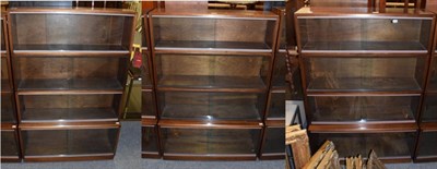 Lot 1234 - A pair of four-tier stacking book shelves; together with a matching taller example (3)