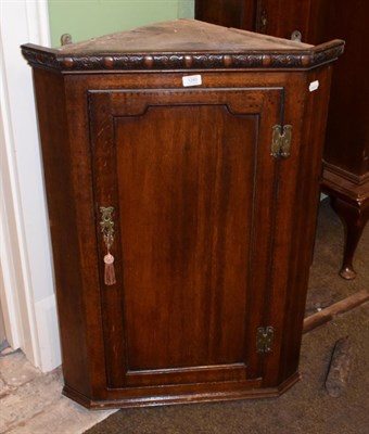 Lot 1280 - A panelled oak corner cupboard with fitted interior