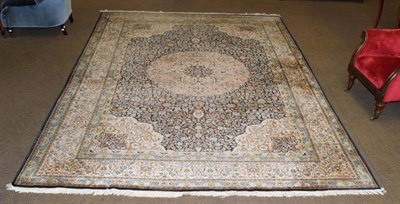 Lot 1341 - A Kashnir silk piled carpet, the indigo field of vines and a central medallion framed by ivory...