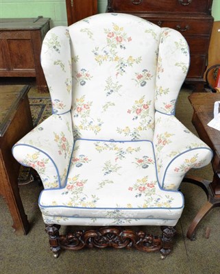 Lot 1359 - A late Victorian/Edwardian oak framed wing armchair in the Carolean style