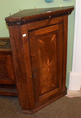 Lot 1393 - A carved oak bedside cabinet and George III inlaid oak corner cupboard