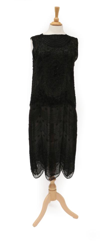 Lot 2126 - Circa 1920s Black Net Shift Dress, with black bugle bead decoration overall in scalloped...