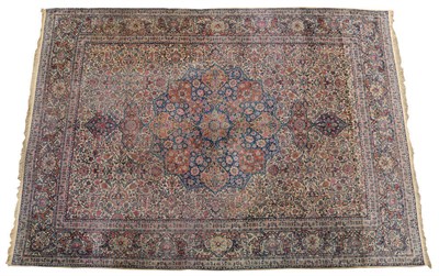 Lot 1407 - Kirman Carpet South East Persia The ivory field of scrolling floral vines around an indigo...