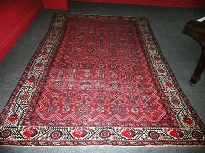 Lot 1414 - Malayir Carpet West Persia The madder field with an allover angular lattice design containing...