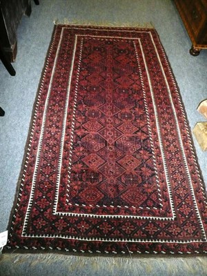 Lot 1419 - Balouch Rug Persian Afghan Frontier The midnight blue and madder field with two columns of diamonds