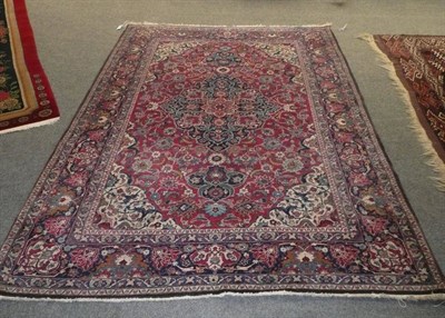 Lot 1420 - Persian Rug of Kashan Design The raspberry field of palmettes and scrolling floral design around an