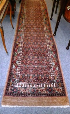 Lot 1435 - Narrow Sarab Runner   North West Persia  The indigo diamond lattice field enclosed by a...