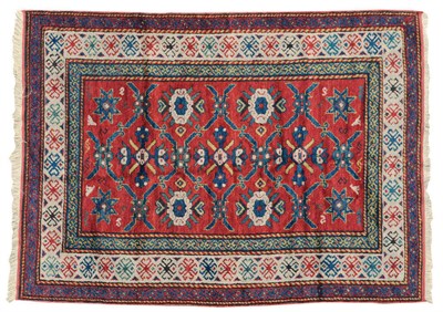 Lot 1445 - Kazak Rug Central Caucasus The madder field with columns of rosettes and stellar devices...