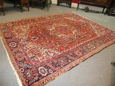 Lot 1453 - Heriz Carpet Persian Azerbaijan The brick red field of angular vines and flowerheads around a...