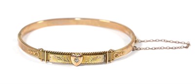 Lot 78 - A 9 carat gold hinged bangle with diamond set heart motif and thistle decoration
