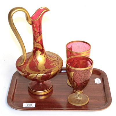 Lot 200 - A 19th century Bohemian three piece gilt highlighted cranberry glass wine set comprising a ewer and