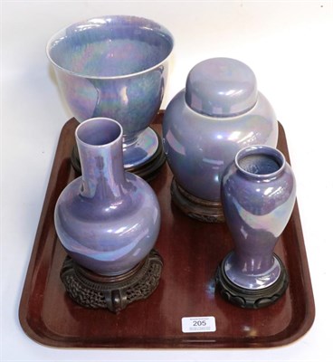 Lot 205 - Three Ruskin purple lustre vases together with a Ruskin ginger jar and cover, each with wooden...