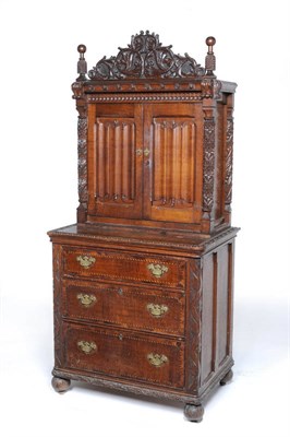 Lot 1473 - A Gothic Style Oak Cabinet on Chest, the upper section with a leaf carved pediment above a...