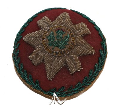 Lot 317 - An early 20th century beadwork pin cushion to the Scots Guards, of circular form, worked with...