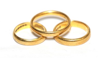 Lot 334 - Three 22 carat gold band rings, finger sizes J, K1/2 and Q (3)
