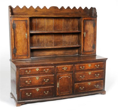 Lot 1484 - An Enclosed Oak Dresser and Rack, the rack with a shaped pediment and two fixed shelves between two