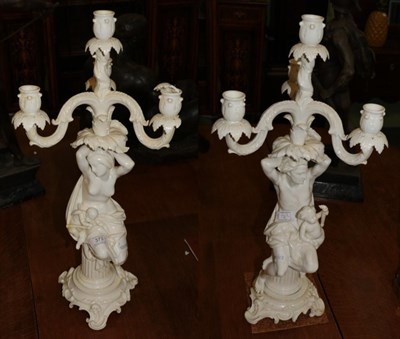 Lot 373 - A pair of Continental white glazed porcelain figural three branch candelabra (a.f)