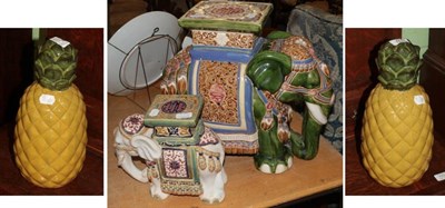Lot 1173 - A pair of glazed pottery pineapple ornaments; and two elephant conservatory tables (4)