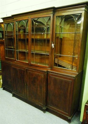 Lot 1507 - A Mahogany Breakfront Bookcase, the bold pediment above two astragal glazed doors enclosing...