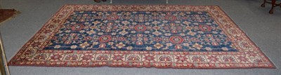 Lot 1355 - An Afghan carpet of Caucasian design, the abrash indigo field of stylised flower heads enclosed...
