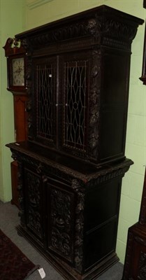 Lot 1387 - A Victorian carved oak bookcase, elaborately carved to the borders, with mask and floral...