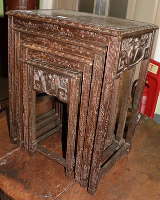 Lot 1392 - A nest of four early 20th century carved nesting tables in the Oriental style, largest table...