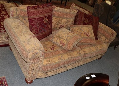 Lot 1421 - A modern two seater sofa upholstered in floral patterned fabric