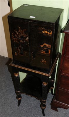 Lot 1503 - An ebonised cabinet raised on a stand with spiral turned legs