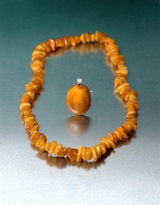 Lot 2025 - An Amber Necklace, comprising of one hundred and thirteen irregular shaped and sized orangey-yellow
