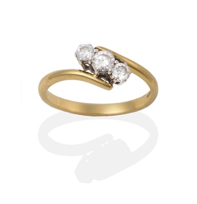 Lot 2026 - An 18 Carat Gold Diamond Three Stone Twist Ring, the round brilliant cut diamonds in white claw...