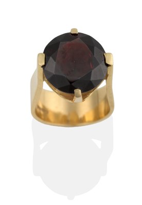 Lot 2033 - A Contemporary 18 Carat Gold Garnet Solitaire Ring, the round brilliant cut garnet in an...